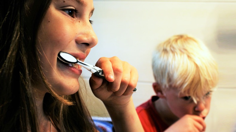 two children brushing teeth