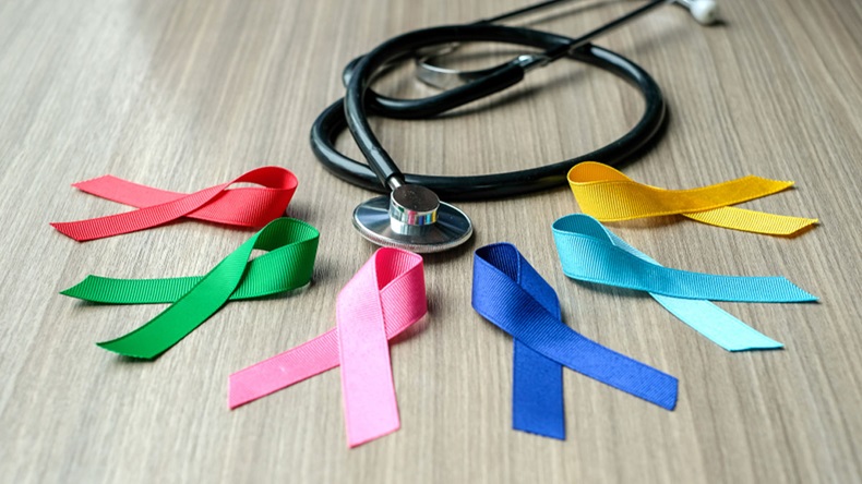 World cancer day (February 4). colorful awareness ribbons; blue, red, green, pink and yellow color on wooden background for supporting people living and illness. Healthcare and medicine concept