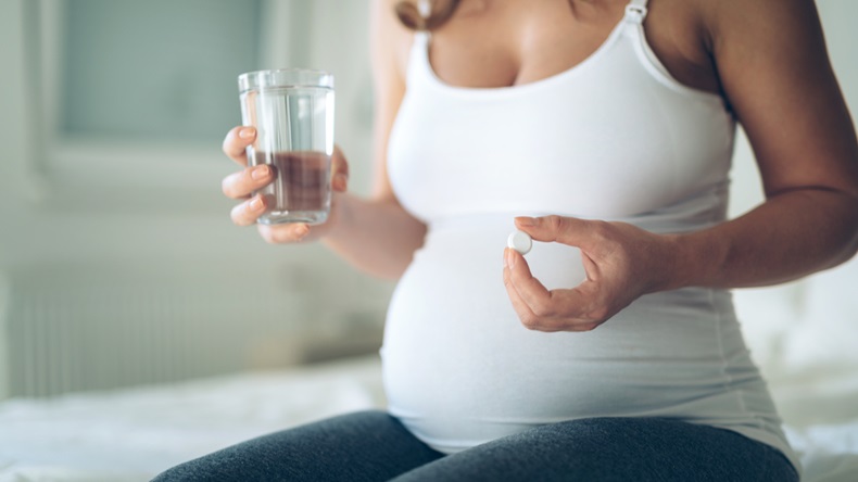 Picture of pregnant woman taking medication pills - Image 