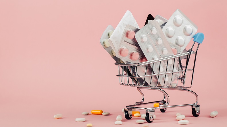 Shopping cart loaded with pills on pink background. The concept of medicine and the sale of drugs. Copy space. - Image 