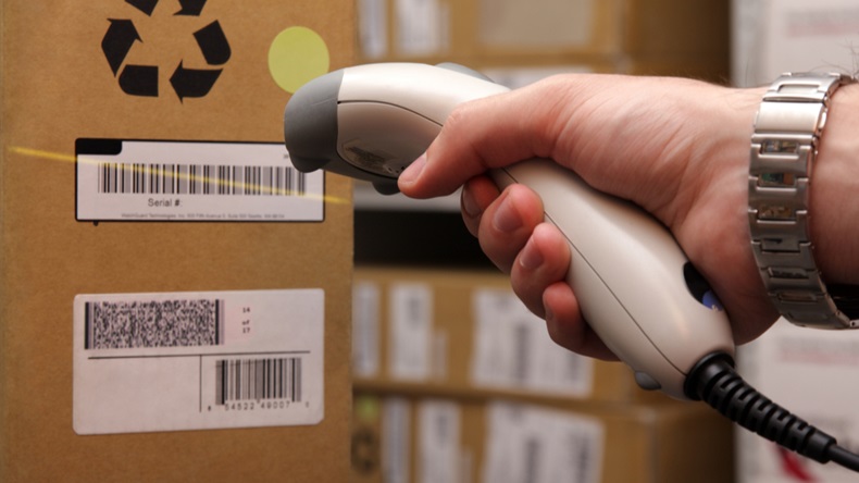 A man gets on the hip reader in operations directed on printed barcode. Warehouse scene. - Image 
