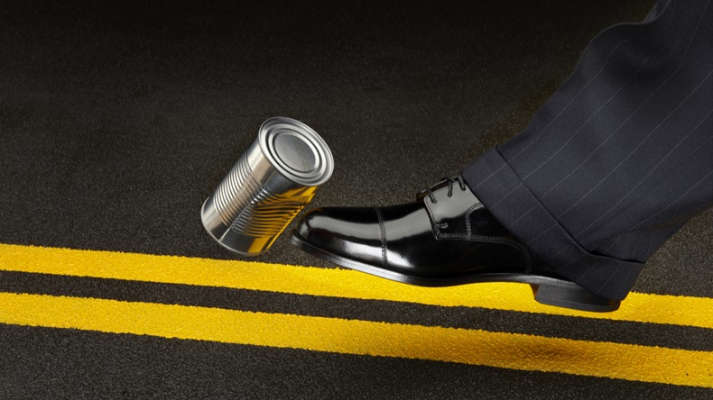close up of politician's shoe kicking a dented shiny can down the road - Image 