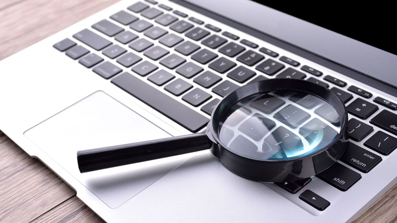 Laptop computer with magnifying glass, concept of search 