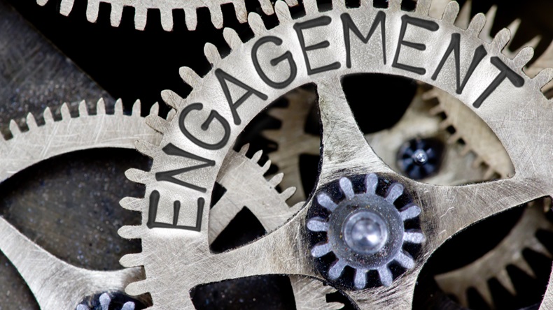 Macro photo of tooth wheel mechanism with ENGAGEMENT concept letters 