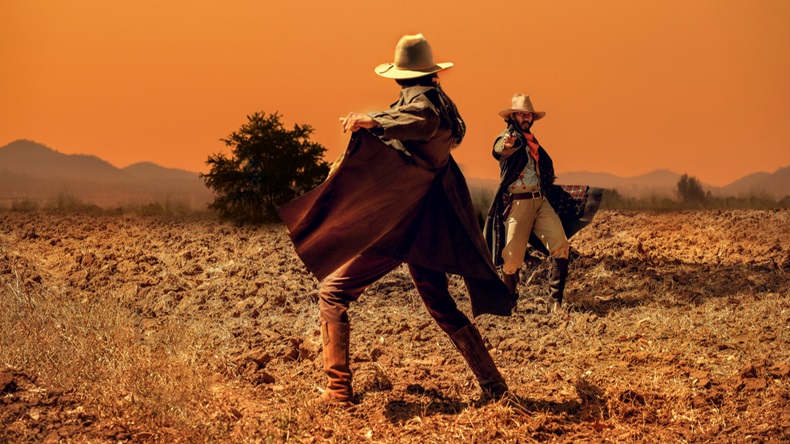 Cowboy Life: pistol shooting in a cowboy action shooting competition under sunset ,duel between cowboys. affair of honor