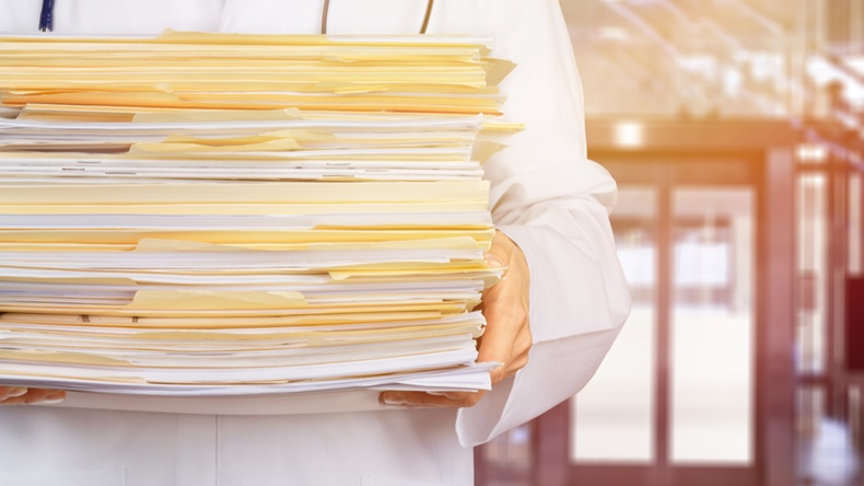 Close-up of a Doctor with Stack of Documents / Files