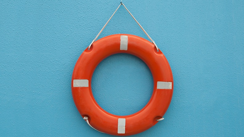 Red life buoy hanging on a blue wall