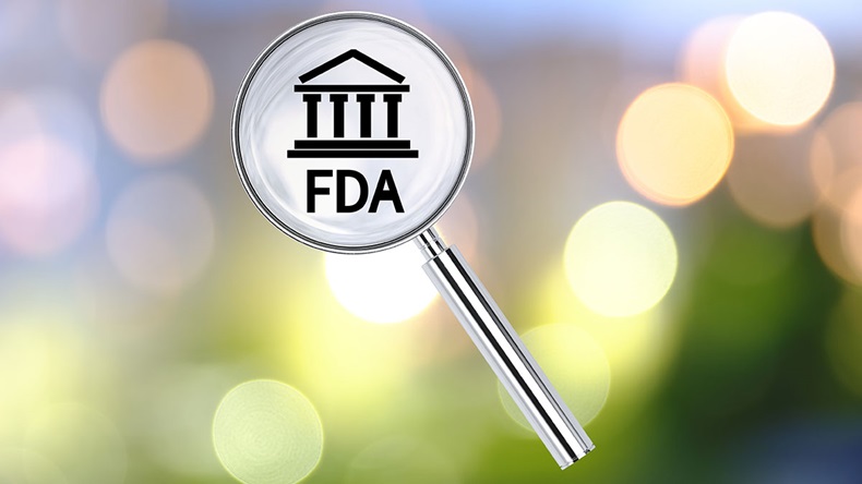 Magnifying lens over background with building icon and text FDA