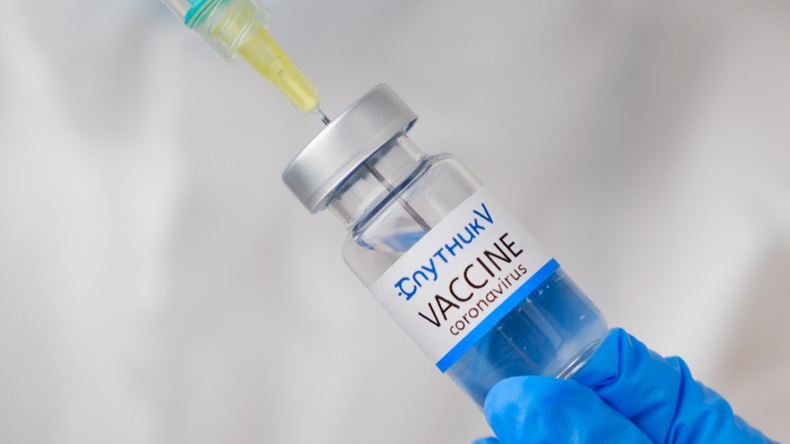 Sputnik V coronavirus Vaccine and syringe in the bottle or vial for injection in doctors hands.