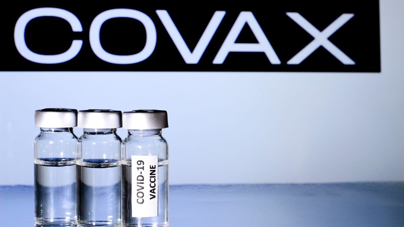 Glass vials with covid-19 vaccine on white background. Covax organization logo in the background.