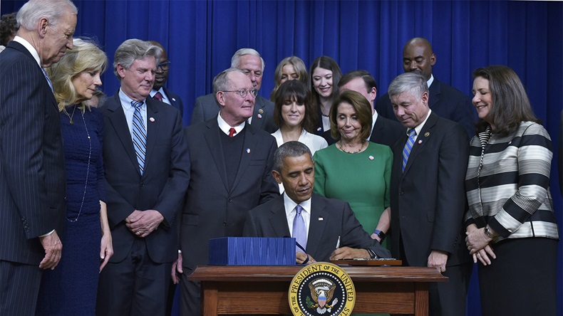 US President Barack Obama signs the 21st Century Cures Act in the South Court Auditorium, next to the White House on December 13, 2016 in Washington, DC. The bill speeds up the approval process for new drugs and medical devices and expands funding for medical research, including the cancer moonshot initiative led by Vice President Joe Biden. The funding will also aid research on opioid abuse and brain diseases, including Alzheimers. (Mandel Ngan/AFP via Getty Images)