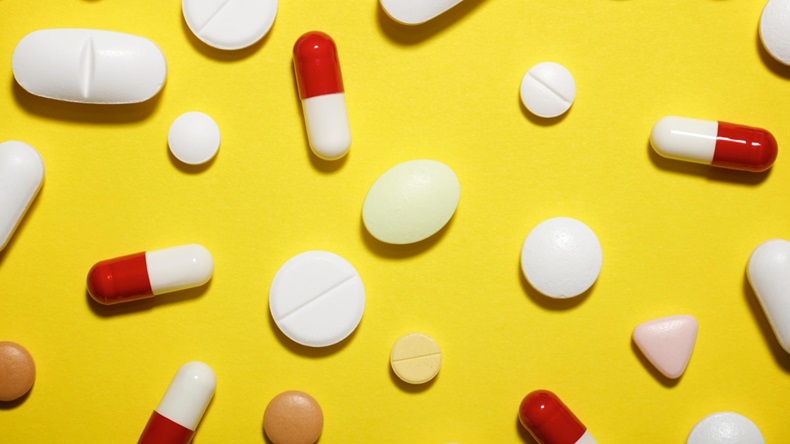 High angle view of various medicines on yellow background