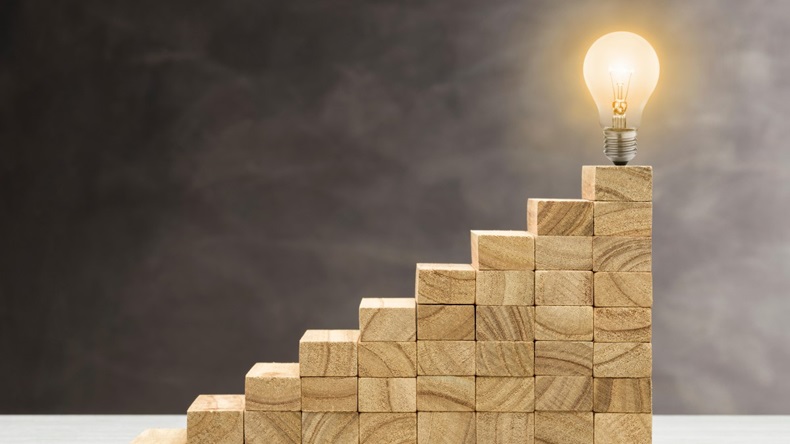 Concept of idea and innovation, light bulb lit on top of a staircase