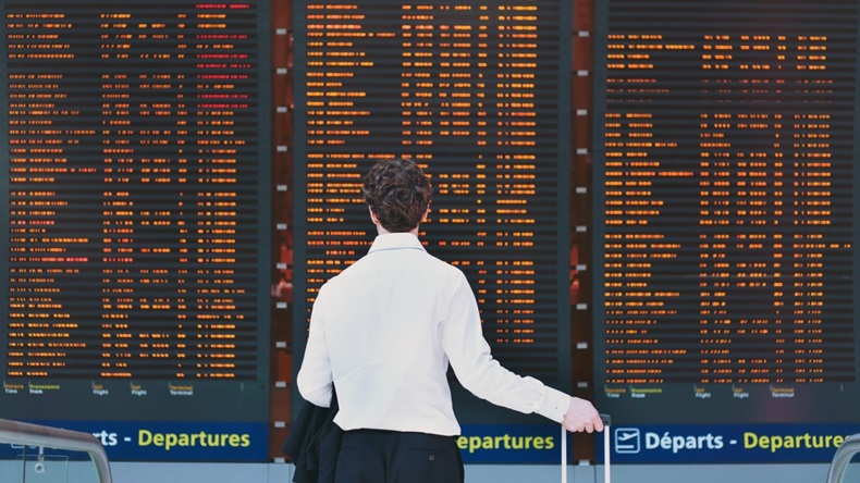 Traveller before an airport departure board