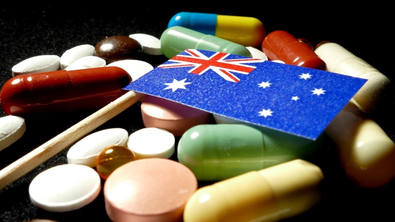 Australian flag with lot of medical pills isolated on black background