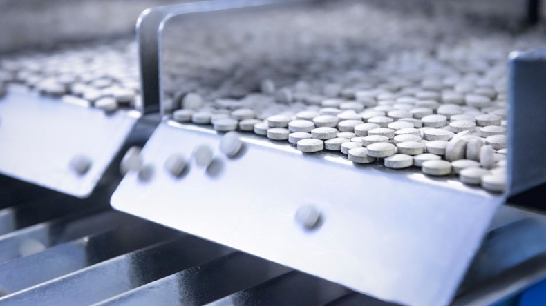 Close up of tablets in packing machine in pharmaceutical factory 