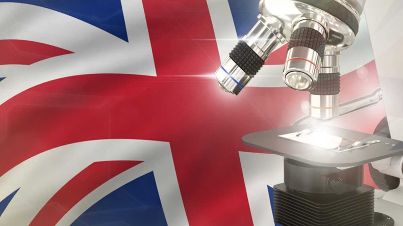 United Kingdom (UK) science development concept - microscope on flag background.