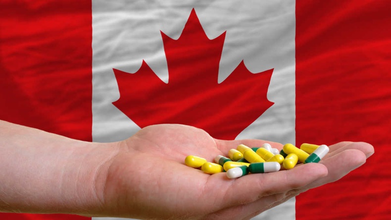 man holding capsules in front of complete wavy national flag of canada