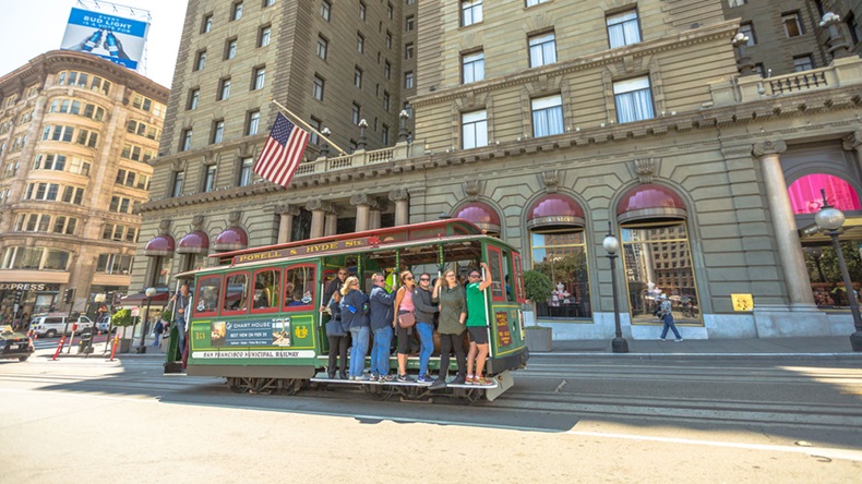 San Francisco, California, United States - August 17, 2016: The Cable Car of San Francisco full of tourists in front of luxurious Westin St. Francis hotel, along the famous Powell Street. - Image 