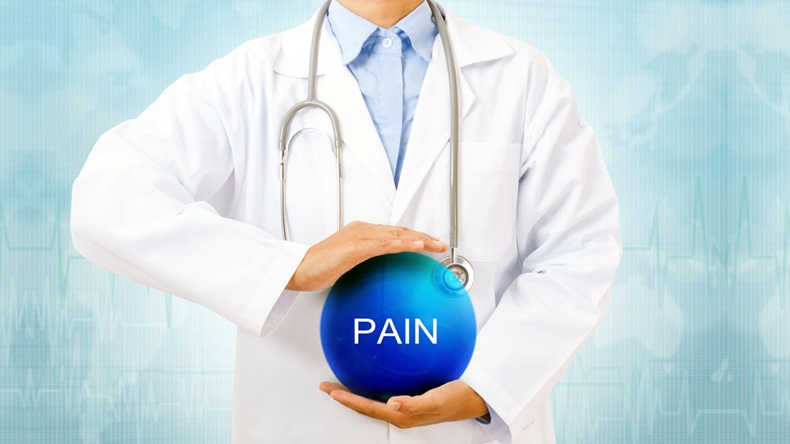 Doctor holding blue crystal ball with pain sign on medical background.