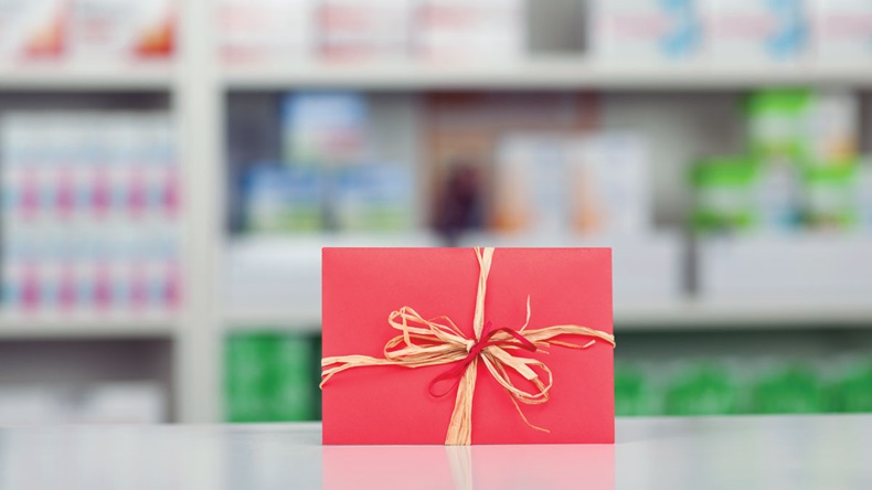 Closeup of gift wrapped in red paper and bow at pharmacy counter